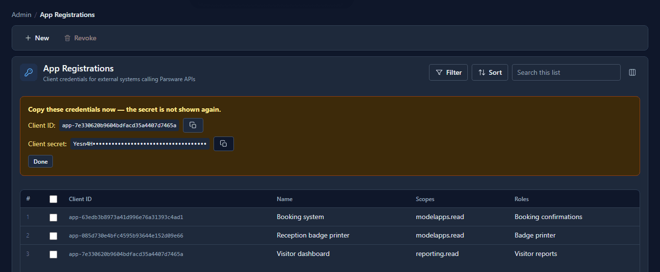 The App Registrations list with a panel above it: Copy these credentials now, the secret is not shown again; the client id app-7e330620…, the client secret partly hidden, and a Copy button beside each. Below, three registrations: Booking system, Reception badge printer and Visitor dashboard